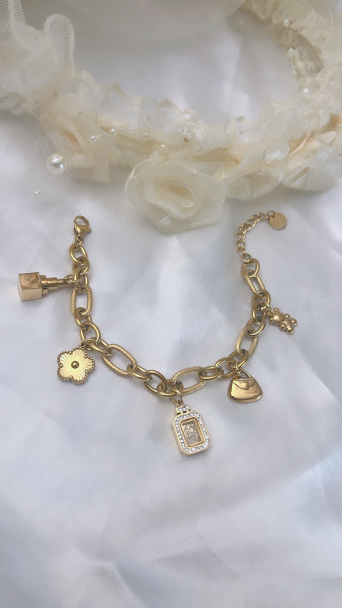 Bracelet doré à charms élégants, composé d’une fleur, d’un sac, d’un pendentif brillant et de détails raffinés. Féminin, tendance et facile à assortir, il apporte une touche de charme et d’élégance à votre poignet. 💫🤍