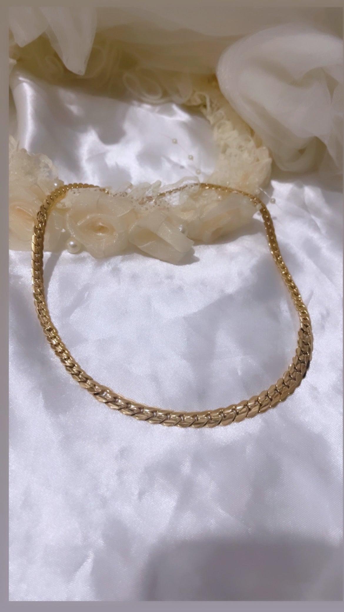Collier au design moderne et élégant, caractérisé par des maillons entrelacés et brillants qui captent la lumière avec raffinement.